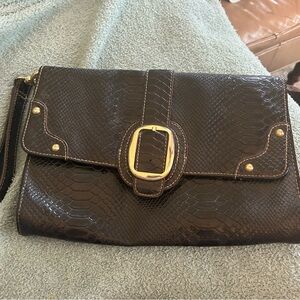 Black snakeskin leather like clutch with wrist handle. 7.5” x 11”